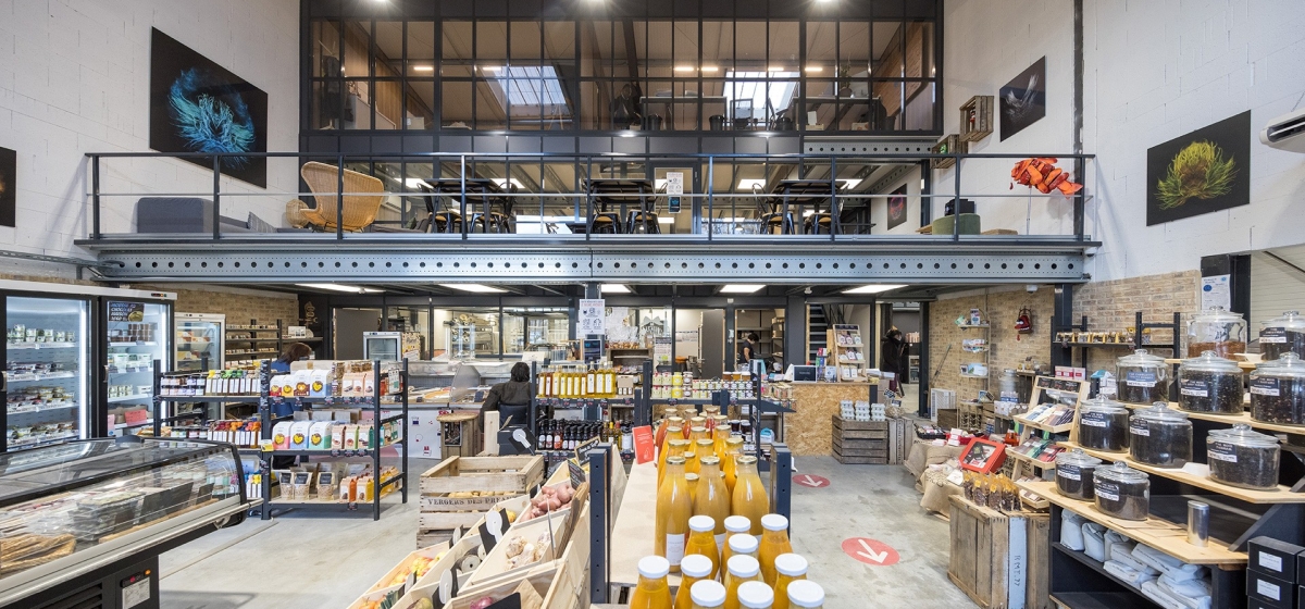 Plataforma metálica que soporta un espacio de coworking en una tienda de alimentación
									                        
