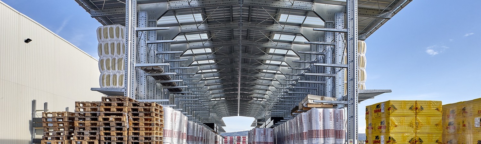 Almacenamiento exterior de materiales en 2 estanterías cantiléver de doble cara equipadas con toldos