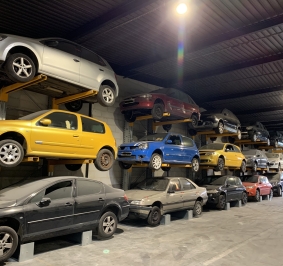 Coches almacenados en altura en una estantería voladiza para cargas pesadas
			