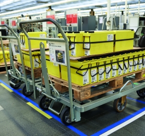 Carretillas motorizadas utilizadas para desplazar piezas en palés dentro de una fábrica
			