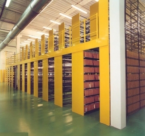 Estanterías de archivo sobre plataforma con pasillos de circulación 
			