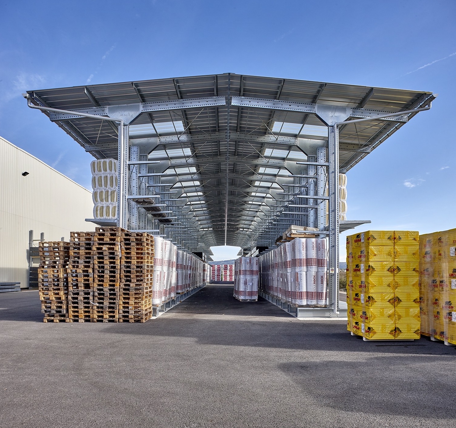 Almacenamiento exterior de materiales en 2 estanterías cantiléver de doble cara equipadas con toldos
			