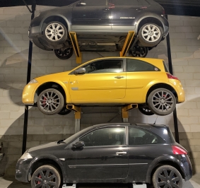 3 coches almacenados bajo techo en estanterías cantiléver
			
