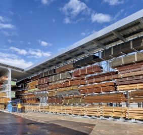 Almacenamiento de madera al aire libre bajo una estantería voladiza con toldo
			
