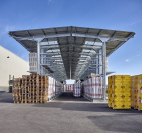 Almacenamiento exterior de materiales en 2 estanterías cantiléver de doble cara equipadas con toldos
			