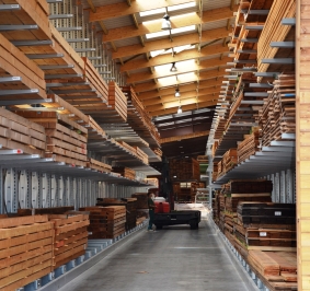 Almacenamiento de madera en estanterías cantilever en una nave autoportante
			