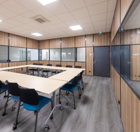 Sala de reuniones equipada con mamparas de oficina y mesas y sillas ergonómicas con ruedas
			