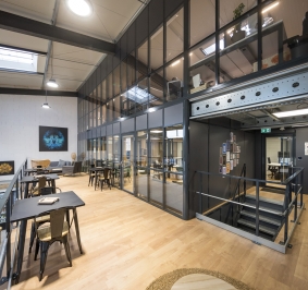 Plataforma de oficinas de 2 niveles con mamparas de cristal
			