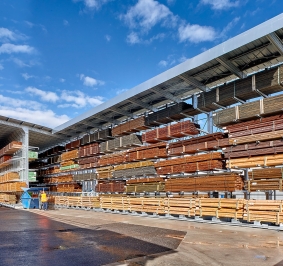 Almacenamiento de madera al aire libre bajo una estantería voladiza con toldo
			