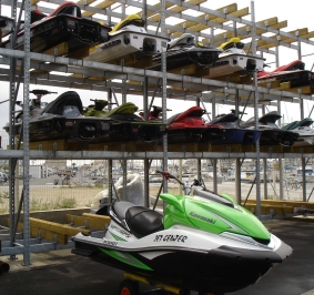 Motos acuáticas guardadas en un estante alto y al aire libre
			