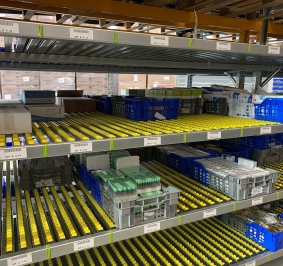 Contenedores apilables almacenados en estanterías dinámicas de rodillos
			
