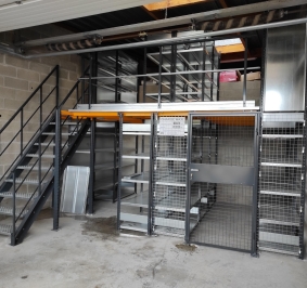 Estanterías de dos niveles con acceso superior mediante una escalera metálica
			
