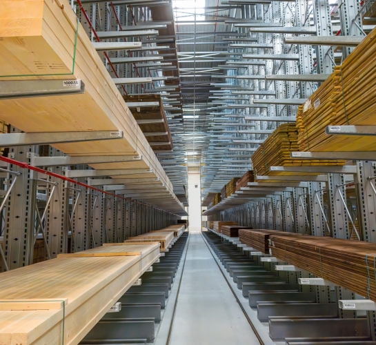 Almacenamiento de madera en un almacén sobre estanterías cantilever altas
                