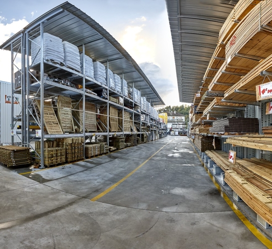 Almacenamiento de madera y cargas paletizadas en estanterías exteriores con toldo
                