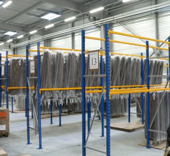 Estanterías Prorack+ utilizadas para almacenar prendas en una fábrica textil 
                