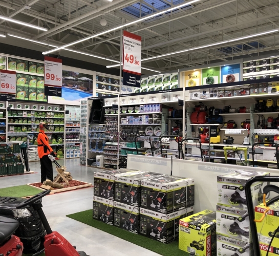 Góndolas y expositores montados para mostrar material de jardinería en una tienda de bricolaje
                