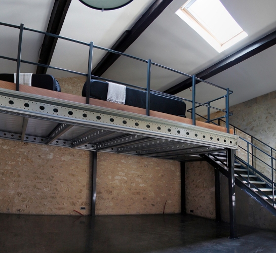 Vista panorámica de una entreplanta metálica con escalera instalada en un desván
                
