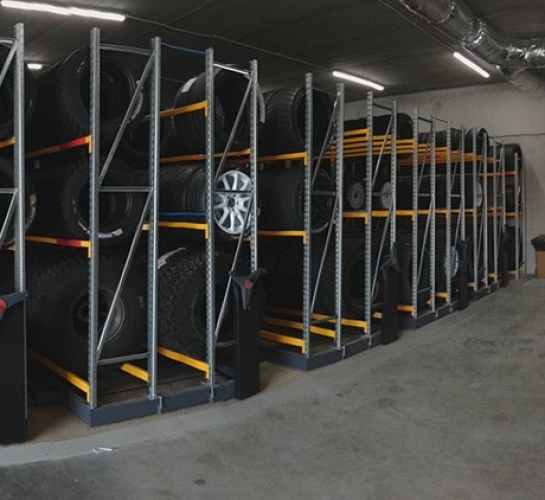 Estantería móvil utilizada en un taller de automóviles para almacenar neumáticos
                