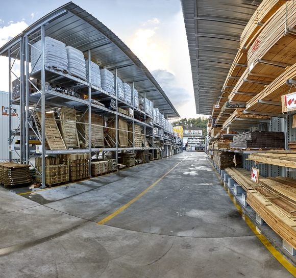 Almacenamiento de madera y cargas paletizadas en estanterías exteriores con toldo