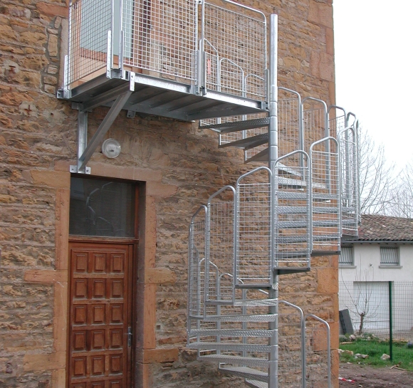 Escalera de caracol de acero que da acceso exterior a la 1ª planta de un edificio