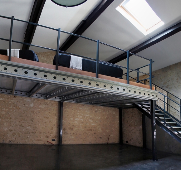 Vista panorámica de una entreplanta metálica con escalera instalada en un desván