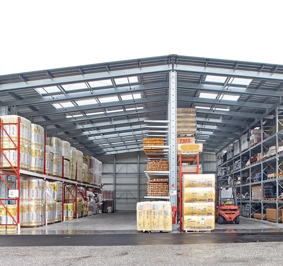 Almacén exterior de materiales, vista frontal, montado con estanterías cantiléver provistas de toldos translúcidos